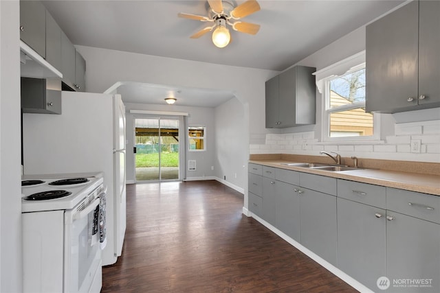 kitchen featuring a sink, decorative backsplash, gray cabinets, and white range with electric stovetop