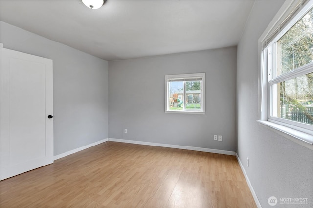 empty room with baseboards and light wood-style floors