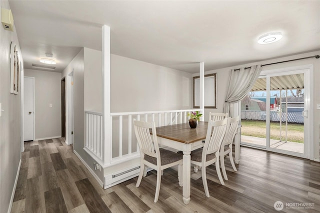 dining space with baseboard heating, baseboards, and wood finished floors