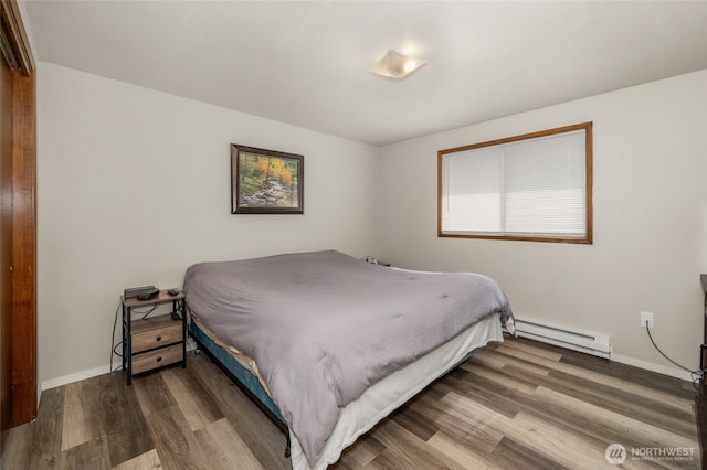 bedroom with wood finished floors, baseboards, and a baseboard radiator