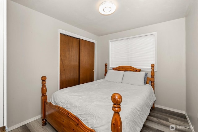 bedroom with wood finished floors, a closet, and baseboards