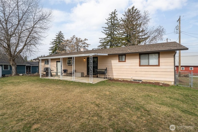 rear view of house with fence, a gate, a patio area, and a lawn