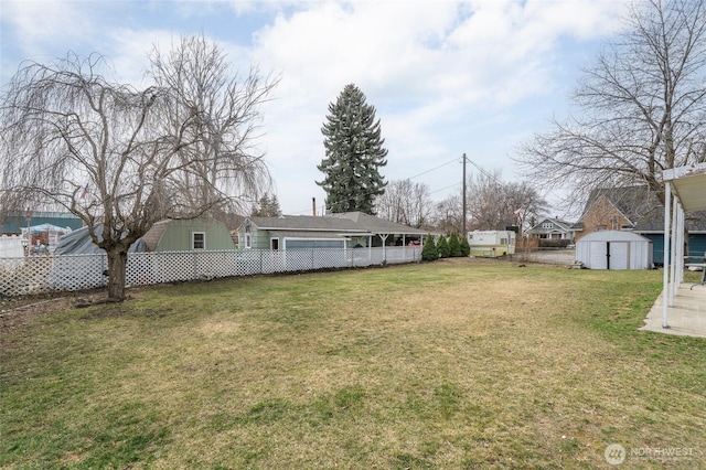 view of yard featuring an outbuilding, a shed, and fence