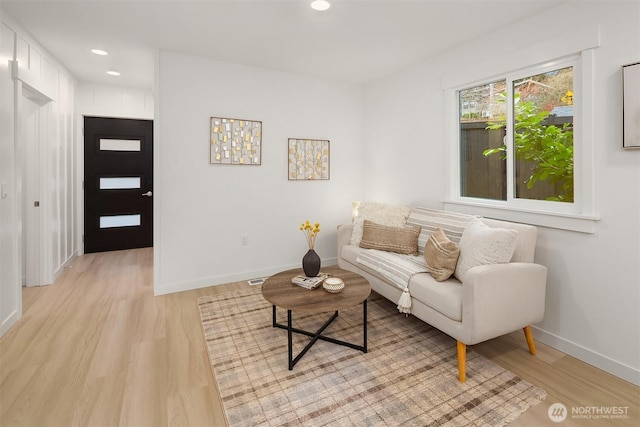 living room featuring recessed lighting, baseboards, and light wood-style flooring