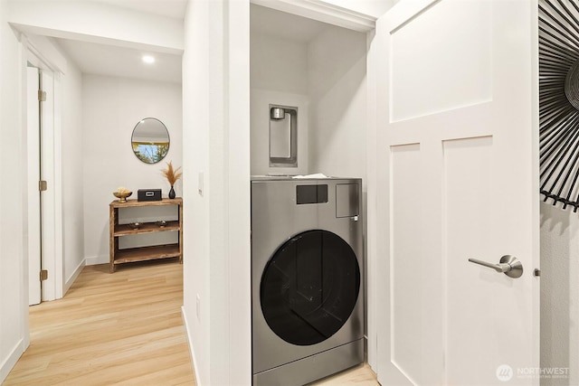 washroom with laundry area, washer / dryer, light wood-type flooring, and baseboards