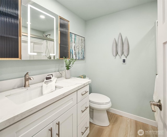 full bath with baseboards, toilet, wood finished floors, a shower with shower door, and vanity