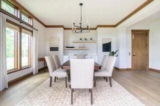 dining space featuring a notable chandelier, wood finished floors, and ornamental molding