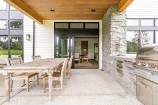 view of patio with area for grilling and outdoor dining space