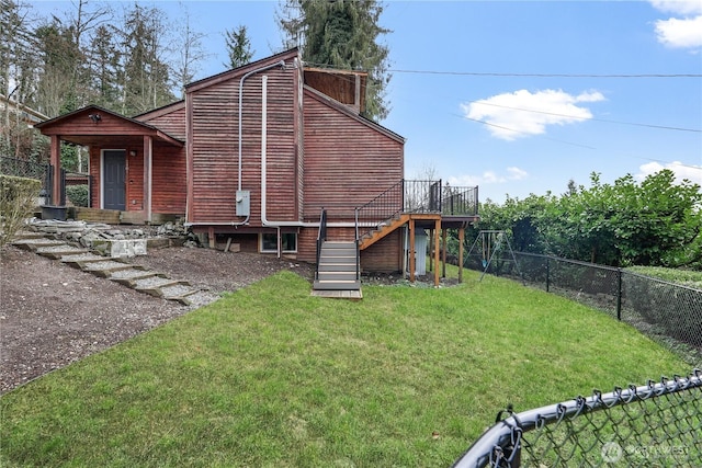 view of side of home featuring a yard, a deck, stairs, and a fenced backyard