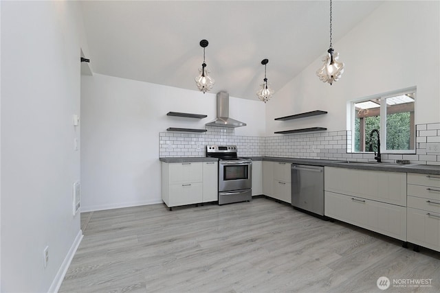 kitchen featuring open shelves, appliances with stainless steel finishes, wall chimney exhaust hood, and a sink