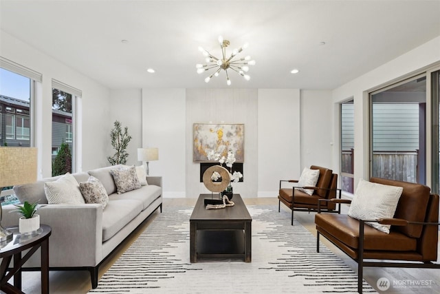 living room featuring recessed lighting, baseboards, and a chandelier