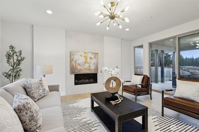 living area featuring a chandelier, recessed lighting, light wood finished floors, and a fireplace