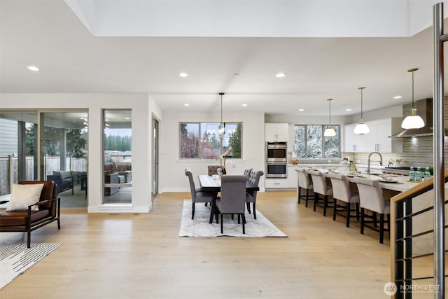 dining area featuring recessed lighting, light wood-type flooring, and baseboards