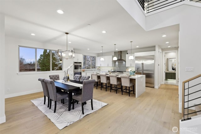 dining room featuring light wood-style flooring, recessed lighting, and baseboards