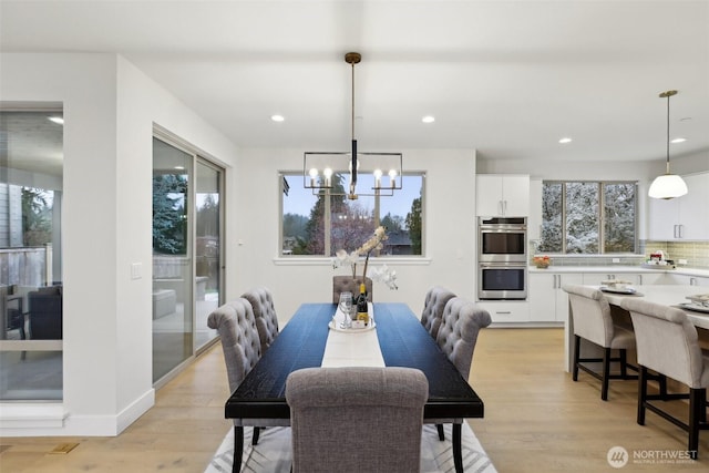 dining room with recessed lighting, baseboards, a notable chandelier, and light wood-style flooring