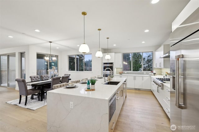 kitchen featuring a sink, appliances with stainless steel finishes, white cabinetry, modern cabinets, and tasteful backsplash