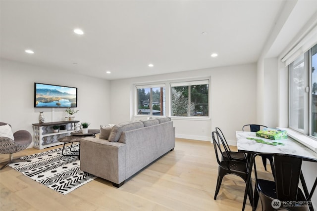 living area featuring recessed lighting, baseboards, and light wood finished floors