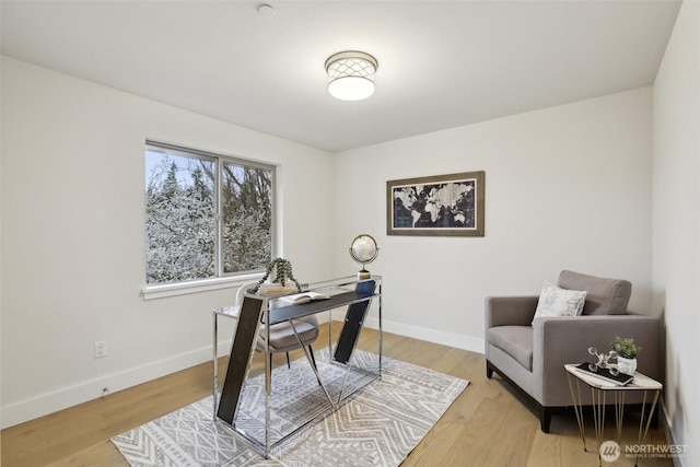 home office with light wood-style flooring and baseboards