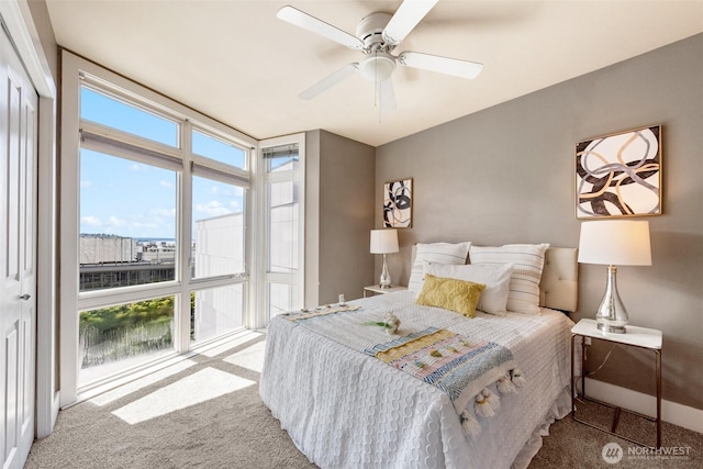 bedroom featuring a wall of windows, a ceiling fan, and carpet flooring