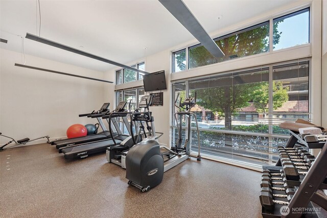 gym with visible vents and a towering ceiling