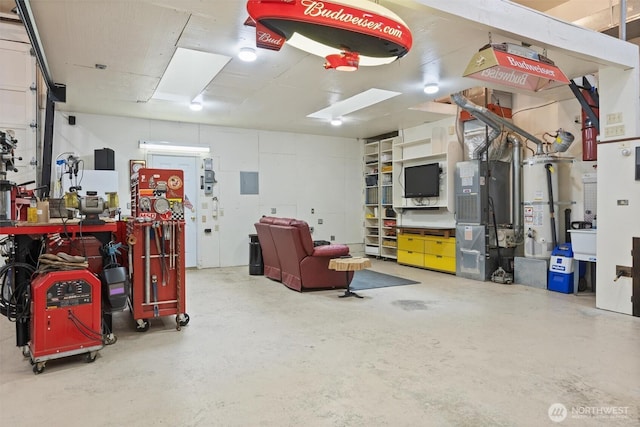 garage with water heater, heating unit, a workshop area, and electric panel