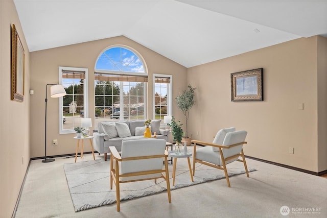 carpeted living area with baseboards and lofted ceiling