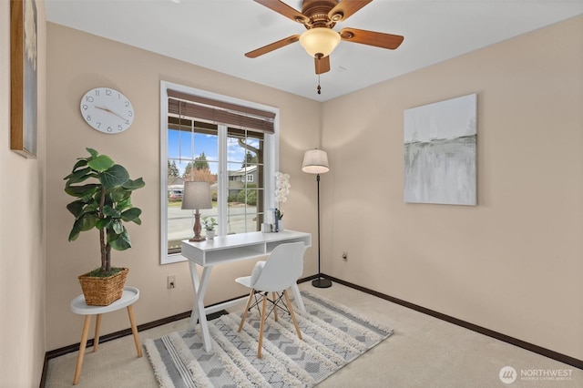 carpeted home office with a ceiling fan and baseboards