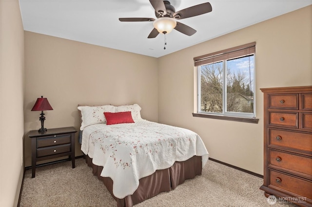 bedroom featuring baseboards, light colored carpet, and ceiling fan