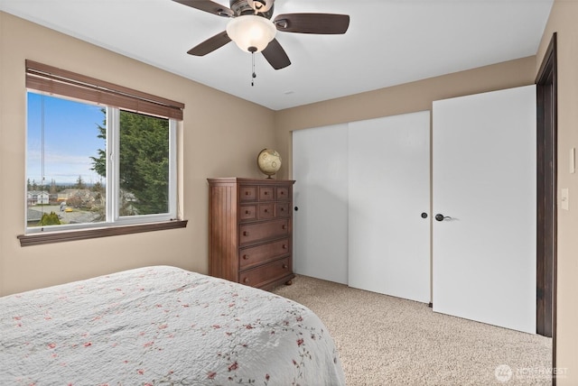 bedroom featuring ceiling fan, a closet, and light carpet