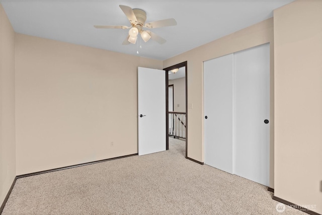 unfurnished bedroom featuring a ceiling fan, carpet, a closet, and baseboards