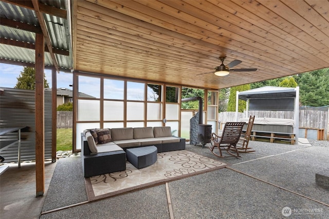 view of patio / terrace featuring an outdoor living space, a hot tub, and a fenced backyard