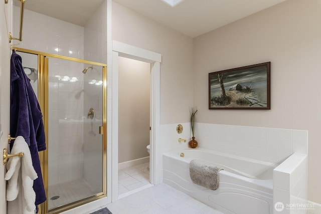 full bath featuring a garden tub, a stall shower, tile patterned flooring, and toilet