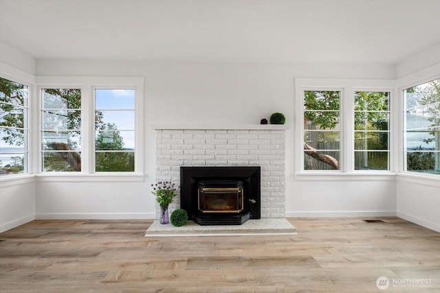 unfurnished living room with visible vents, baseboards, and wood finished floors