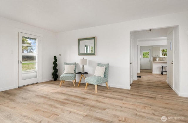 living area featuring light wood-type flooring and baseboards