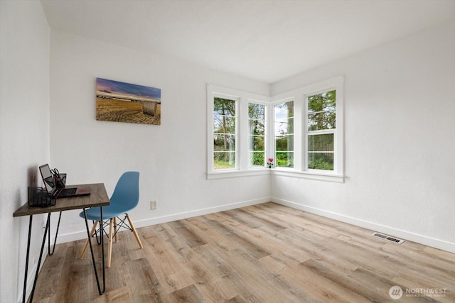 office area featuring visible vents, baseboards, and wood finished floors