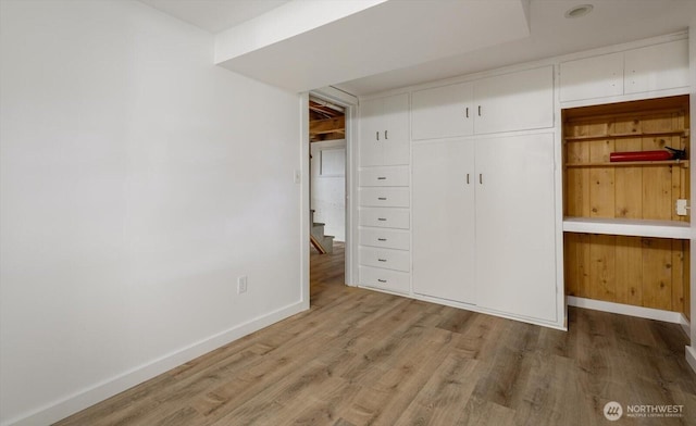 unfurnished bedroom with a closet, baseboards, and wood finished floors