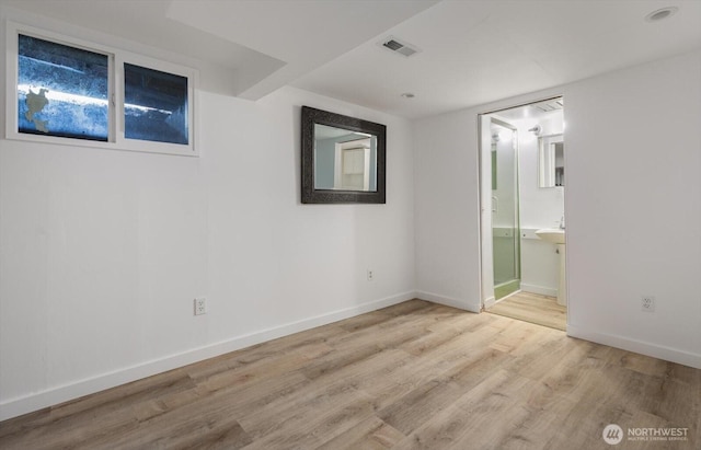 unfurnished bedroom with visible vents, connected bathroom, light wood-type flooring, and baseboards