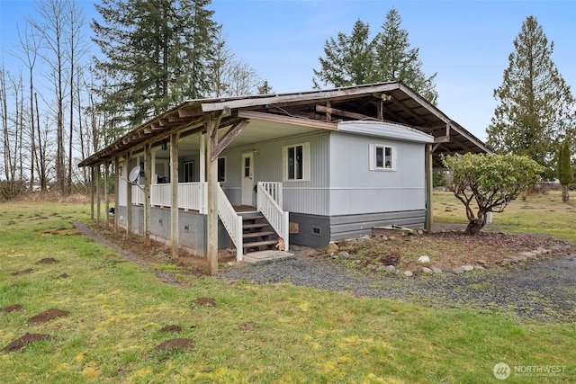 manufactured / mobile home with crawl space, covered porch, and a front lawn