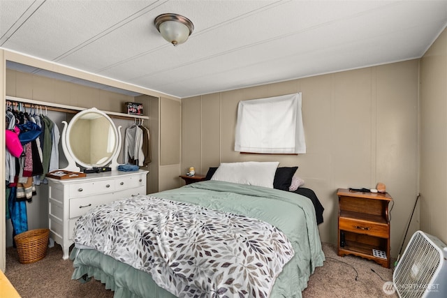 carpeted bedroom featuring a decorative wall and a closet