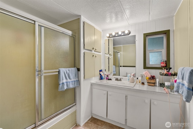 full bathroom with vanity, a stall shower, and a textured ceiling