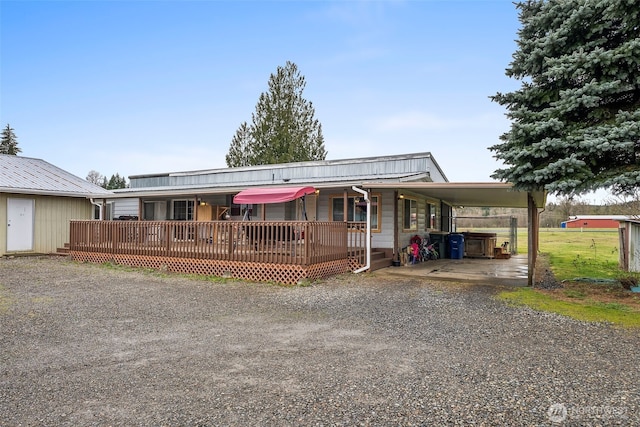 view of front of property featuring an attached carport and gravel driveway