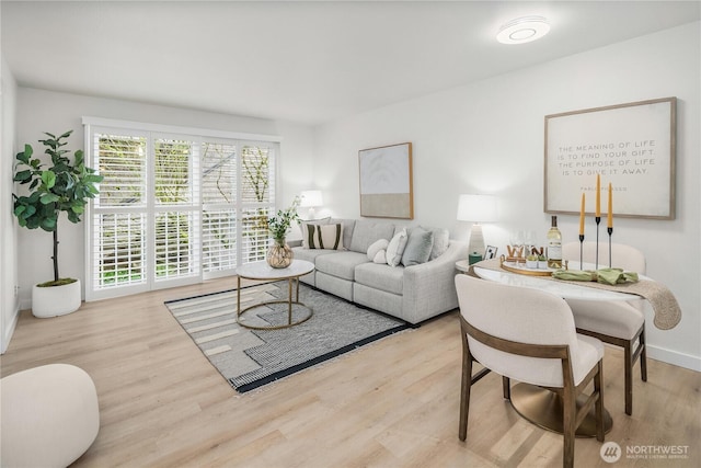 living area with baseboards and wood finished floors