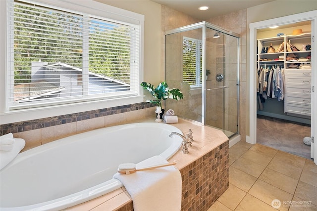 bathroom featuring a stall shower, a healthy amount of sunlight, and tile patterned flooring