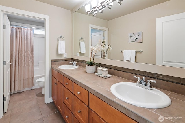 full bathroom featuring tile patterned flooring, double vanity, a sink, and toilet