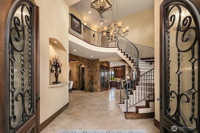 253 E Lake Sammamish Pkwy SE, Sammamish, WA 98074 - foyer with baseboards, arched walkways, stone tile flooring, a chandelier, and stairs