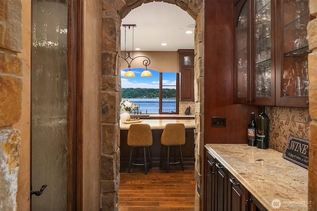 253 E Lake Sammamish Pkwy SE, Sammamish, WA 98074 - bar with arched walkways, a water view, hanging light fixtures, decorative backsplash, and dark wood-style floors