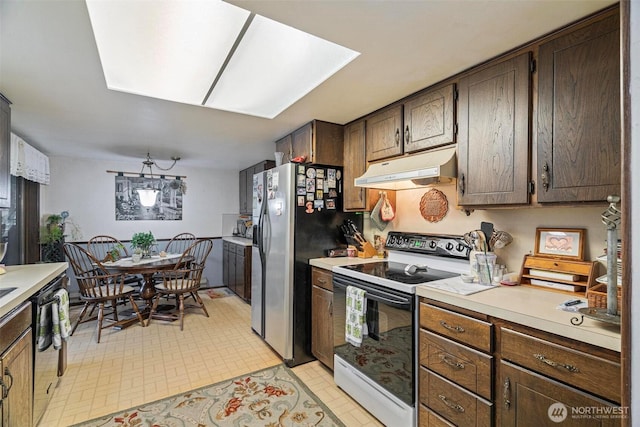 kitchen featuring light countertops, black dishwasher, stainless steel refrigerator with ice dispenser, under cabinet range hood, and range with electric stovetop