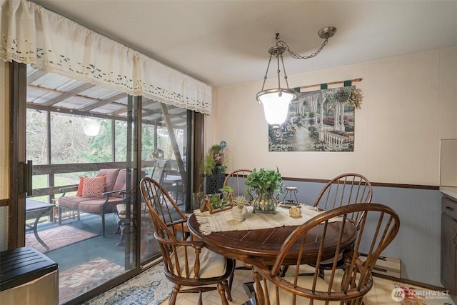 dining room featuring wallpapered walls and a sunroom