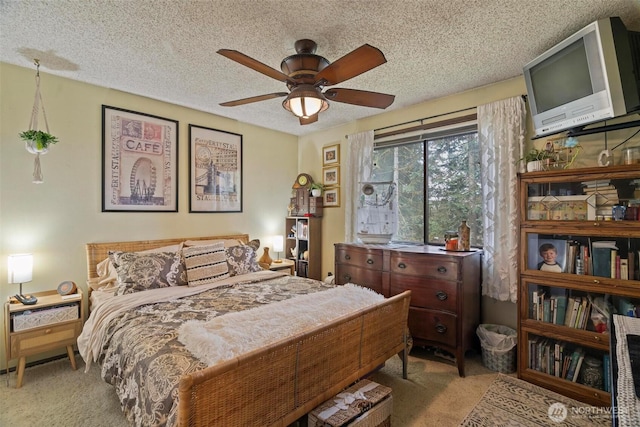 bedroom featuring ceiling fan, carpet, and a textured ceiling