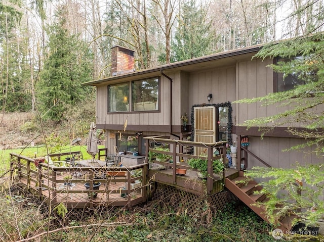 rear view of property featuring a deck and a chimney